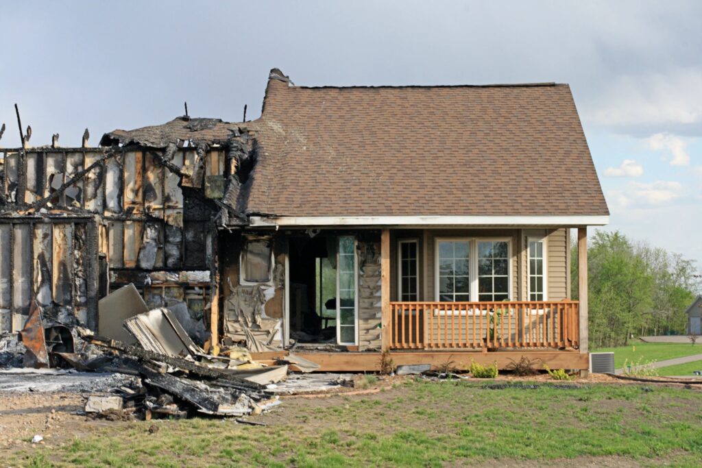 House with severe fire damage on one side and intact on the other.