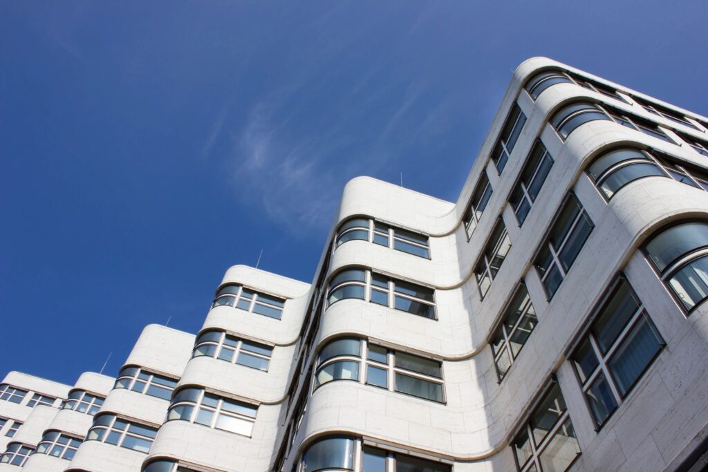 Modern white building with rounded corners against a clear blue sky.