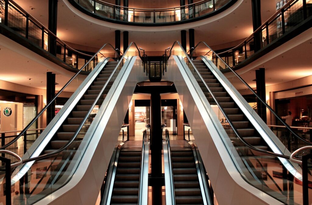 Symmetrical escalators inside a modern, stylish building at night.